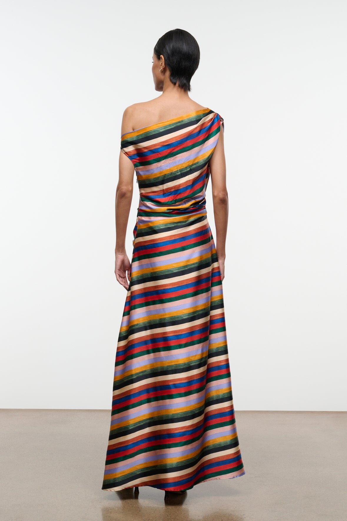 Striped silk maxi dress back view with one-shoulder drape and long flowing skirt