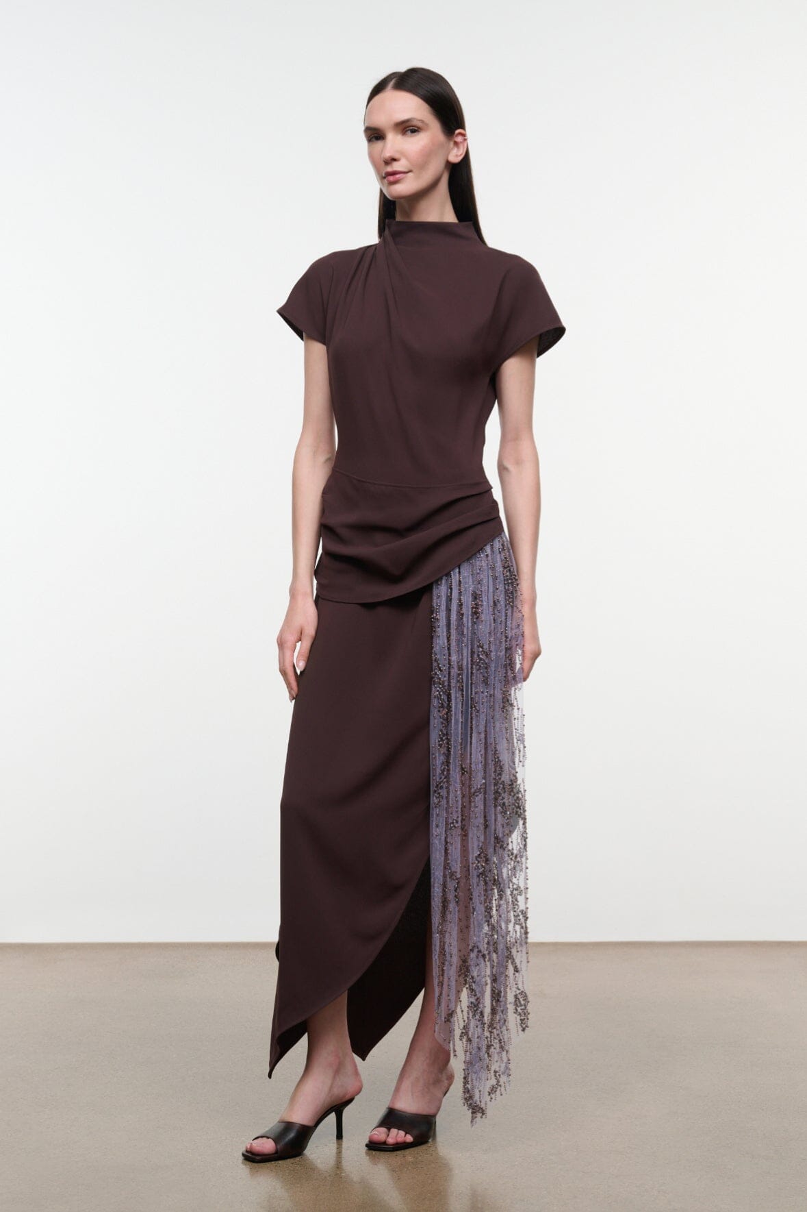 High-neck midi dress in dark brown with short sleeves, draped waist, and asymmetrical fringe panel