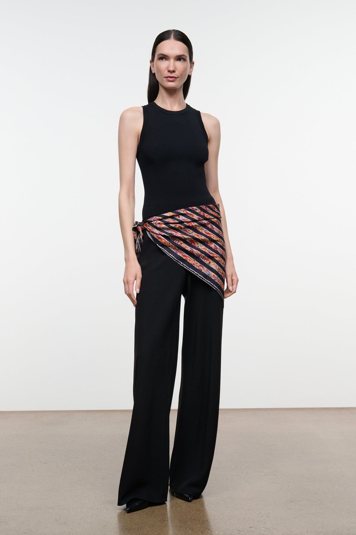 Cecile silk scarf with black base and orange-red abstract stripes, draped on model