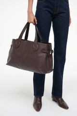 Espresso-brown tote bag with top handles and front zip pull detail