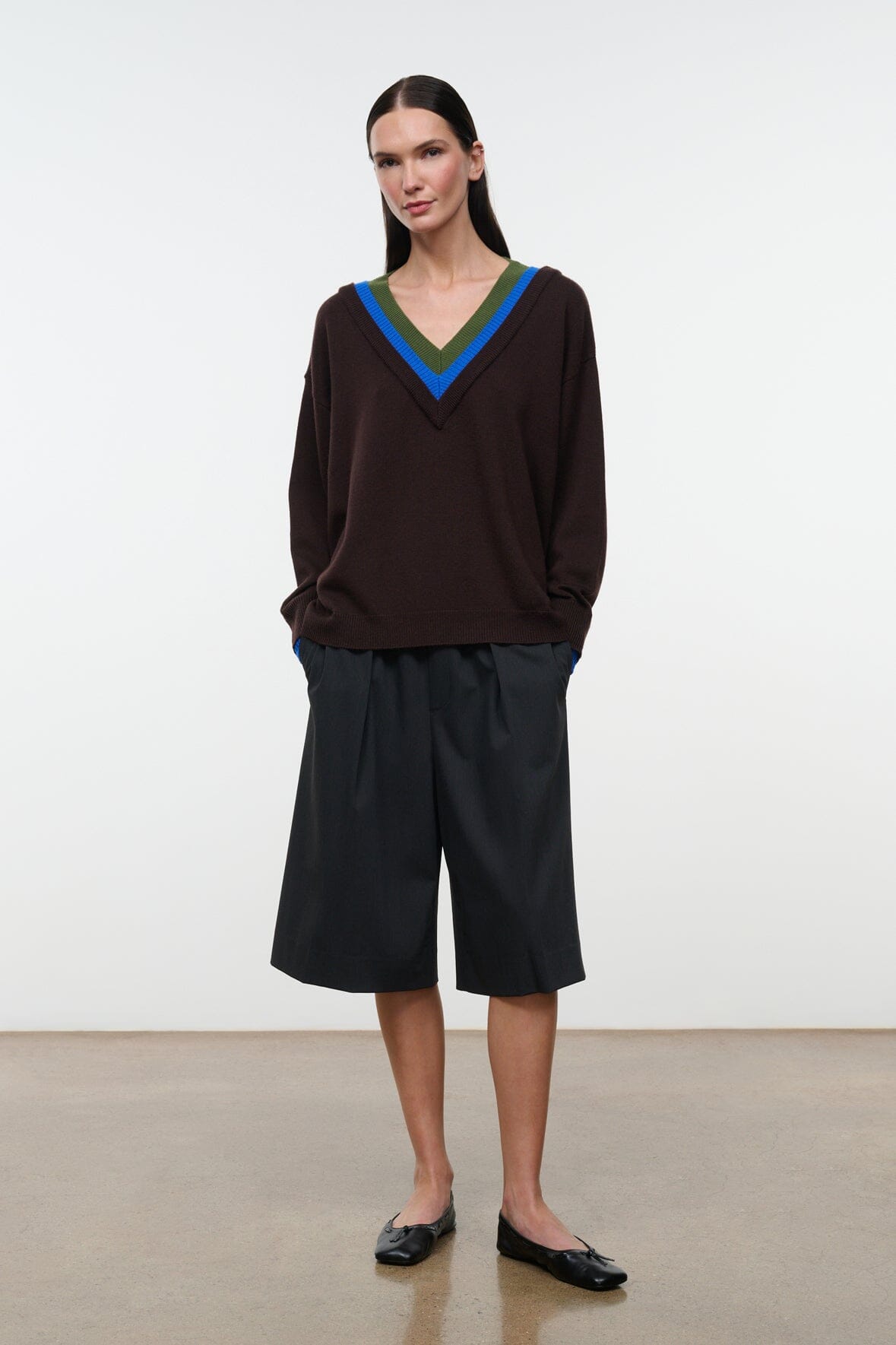 Black flat ballet shoes worn with dark culottes, pointed toe and bow