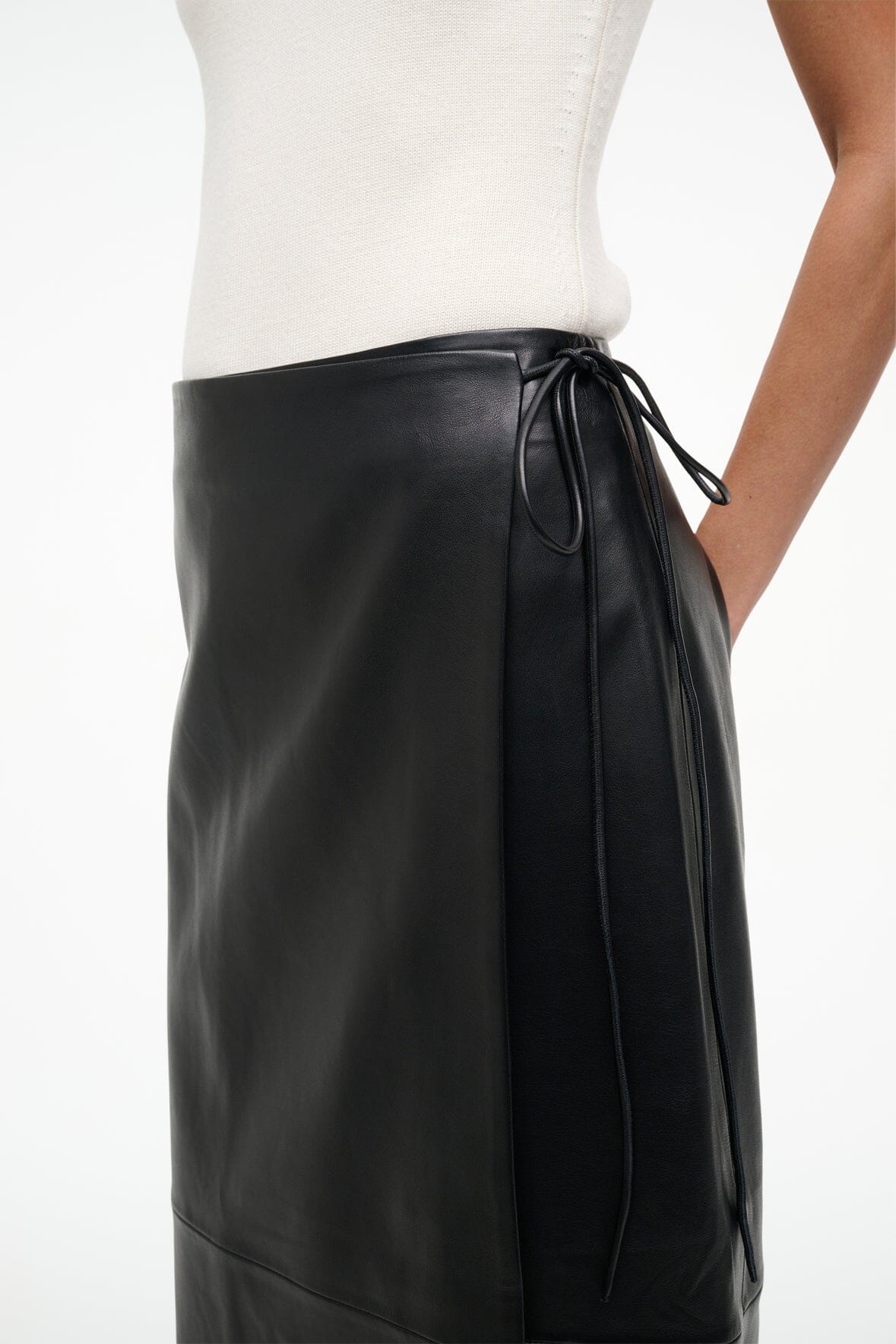 Black leather wrap skirt close-up, waist tie strings and wrap panel