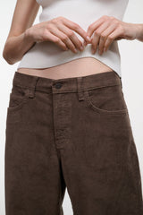 Dark brown corduroy jeans detail: front button and waistband, relaxed wide-leg fit