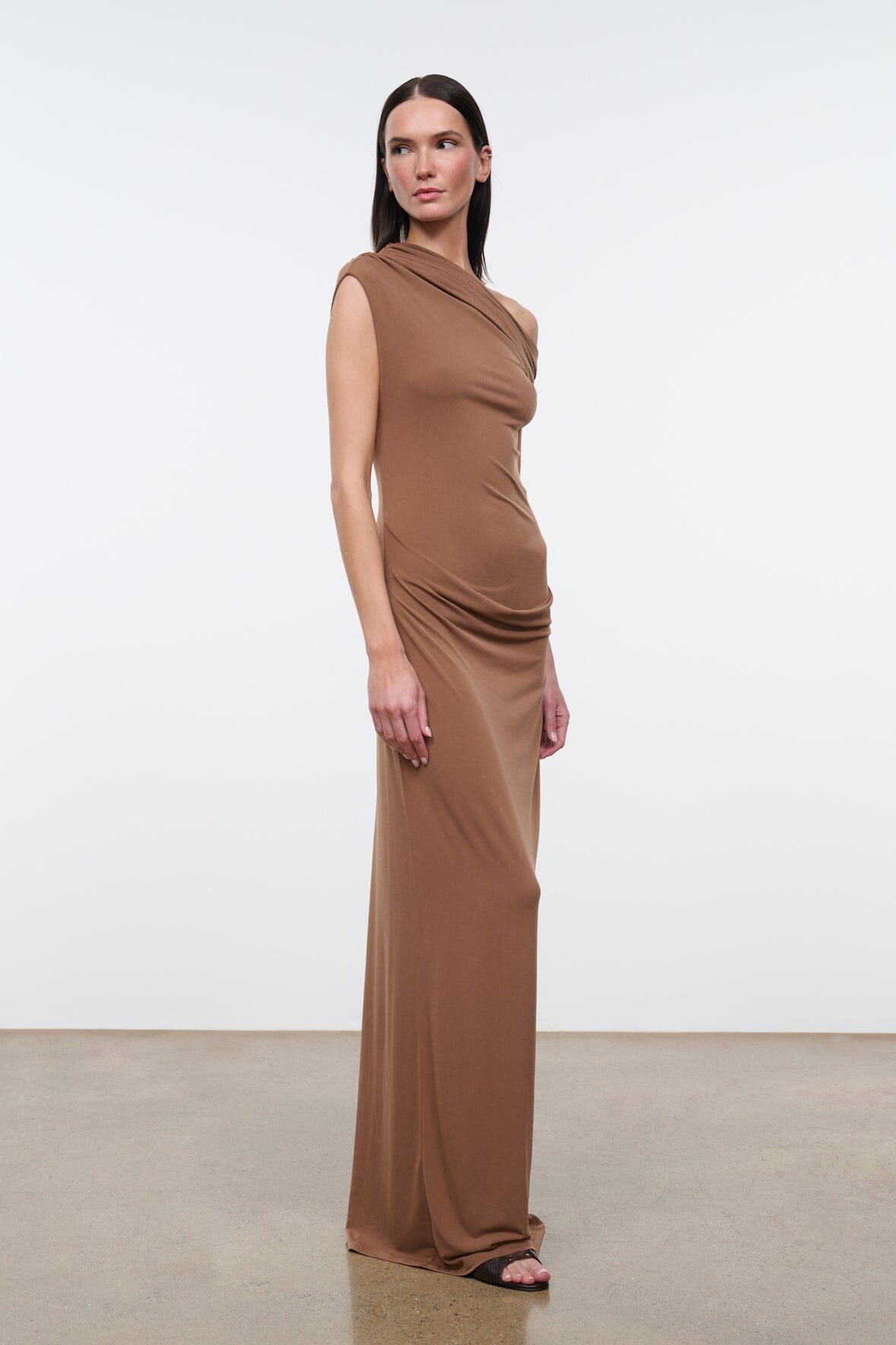 Women's draped one-shoulder maxi dress in warm brown, front view.