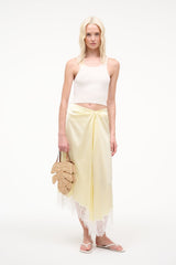 Natural tan raffia leaf mini bag on model with tan leather handles