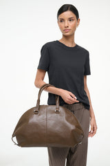 Truffle brown large rounded satchel with top handles and zip closure.