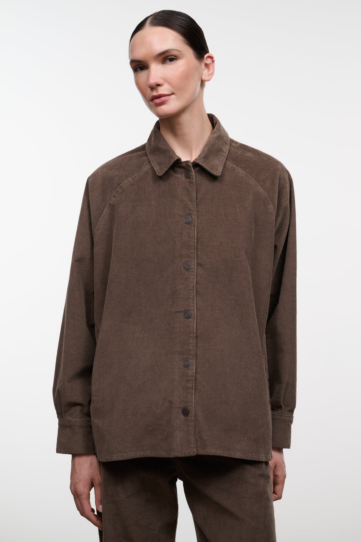 Brown corduroy shirt jacket with long sleeves and buttoned front