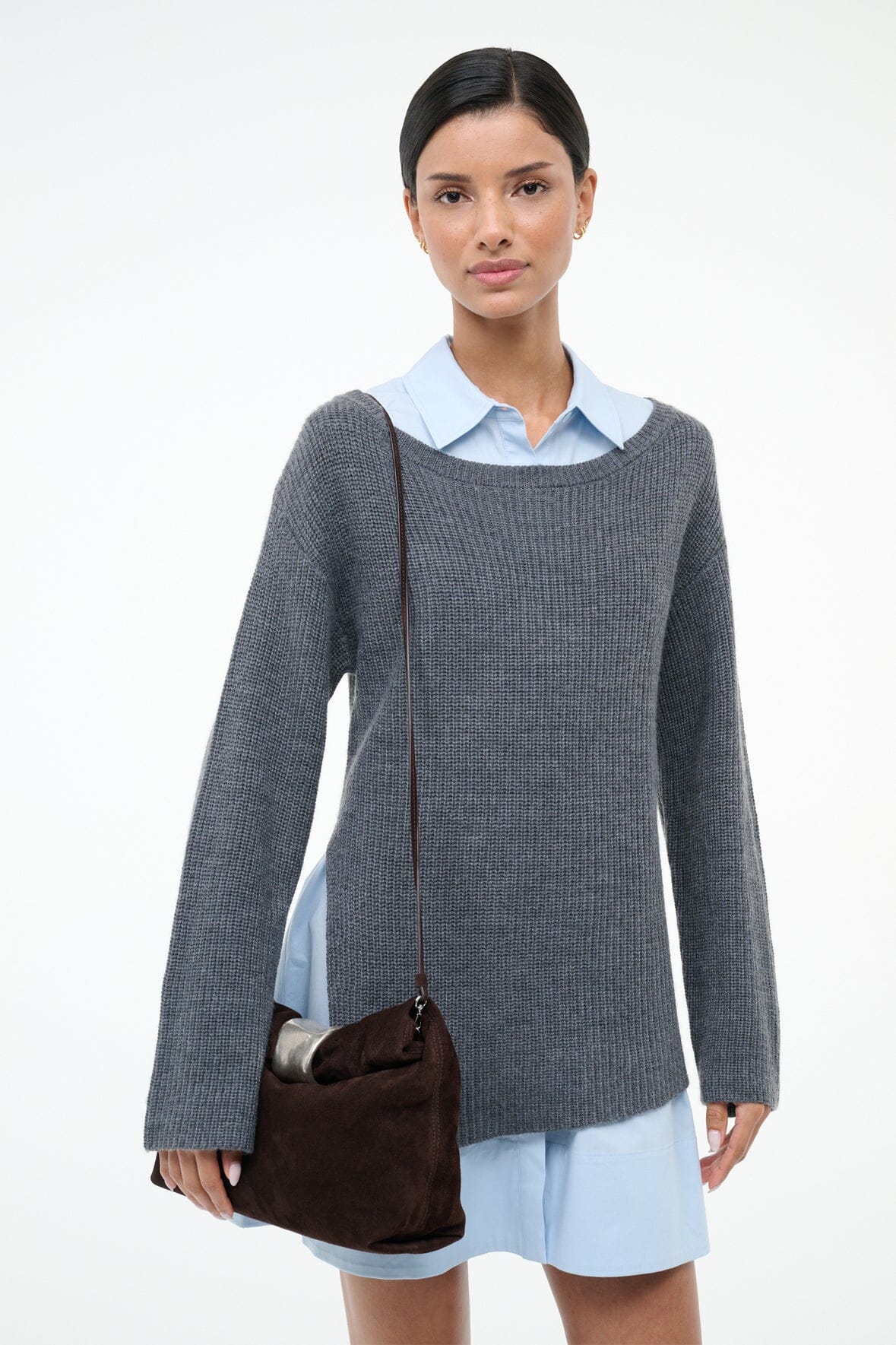 Espresso suede cuff clutch with metal-tone cuff detail, worn at side