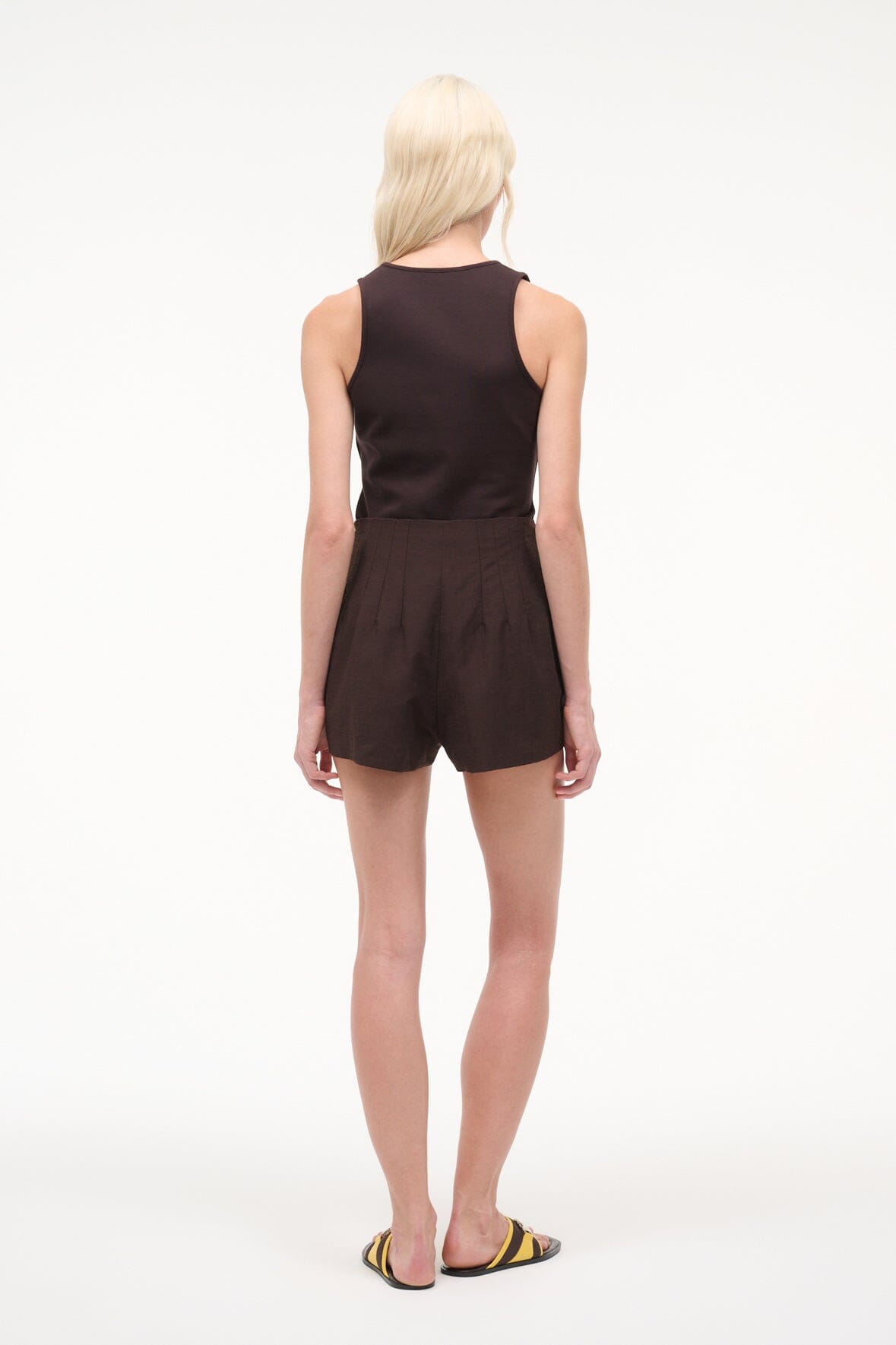 Dark brown sleeveless V-neck romper with belted waist and short shorts