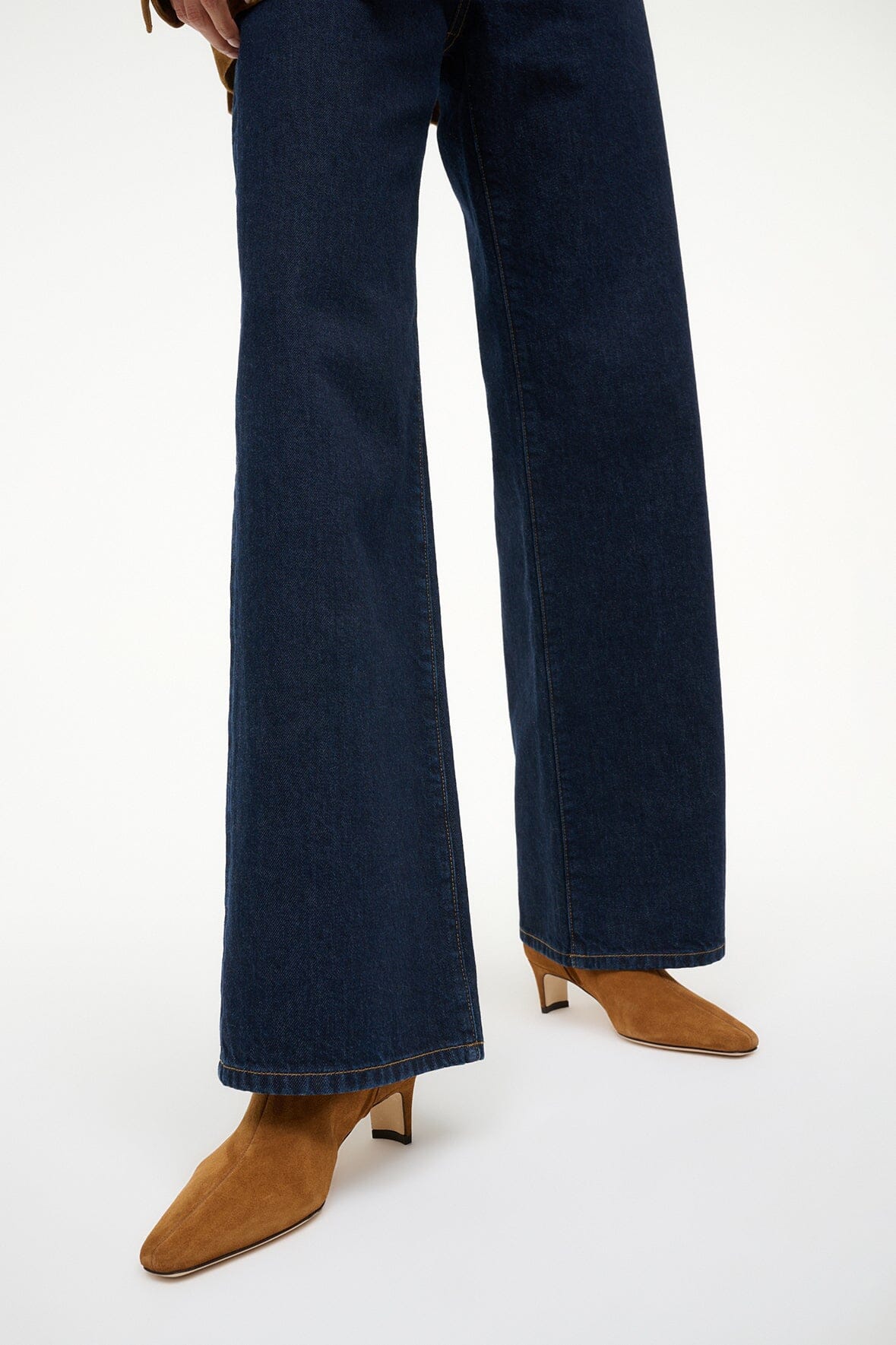 Tan suede ankle boots worn with dark blue jeans and low block heel