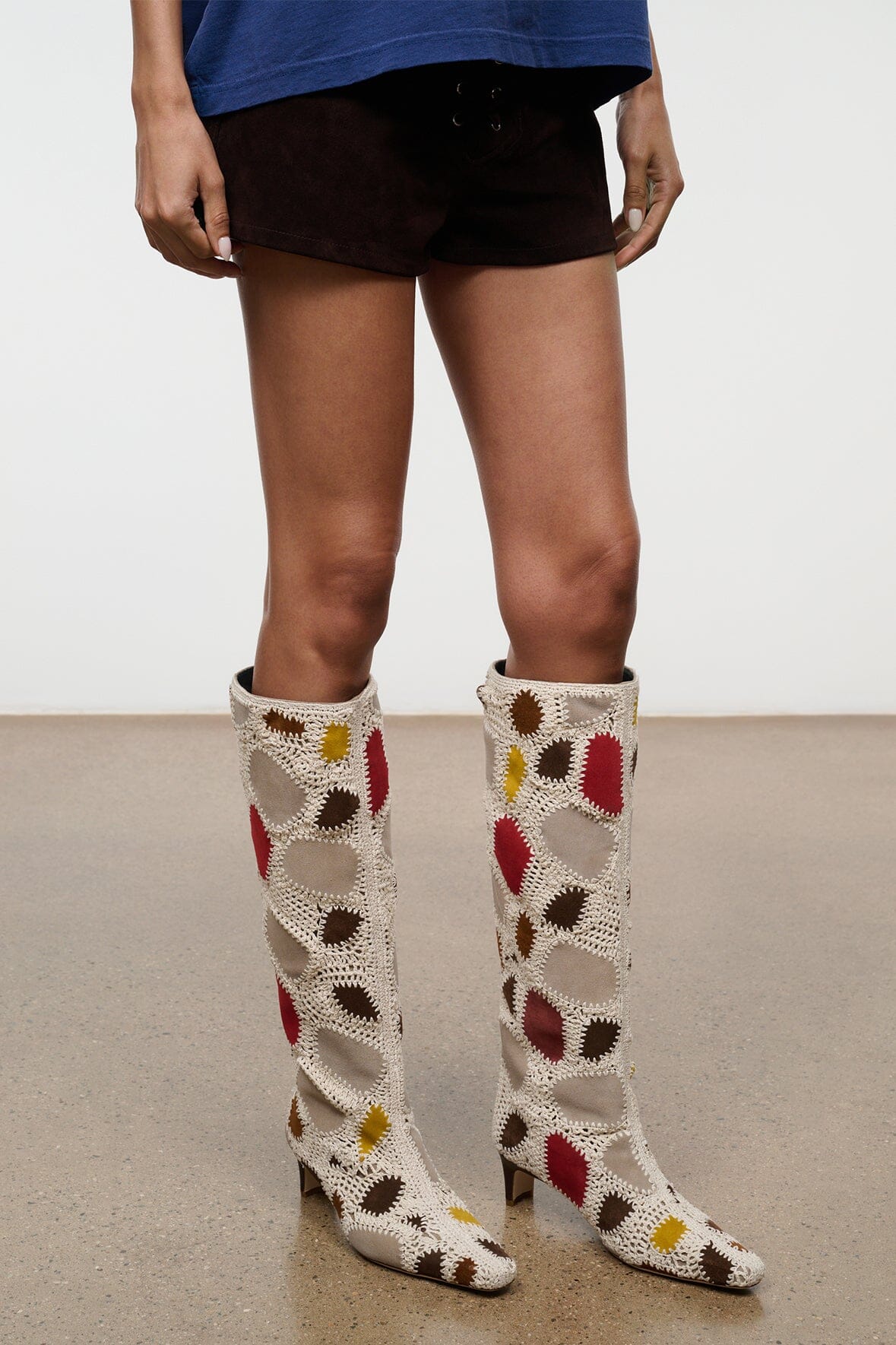 Pair of tall suede patchwork boots, cream with red and yellow accents and low heel