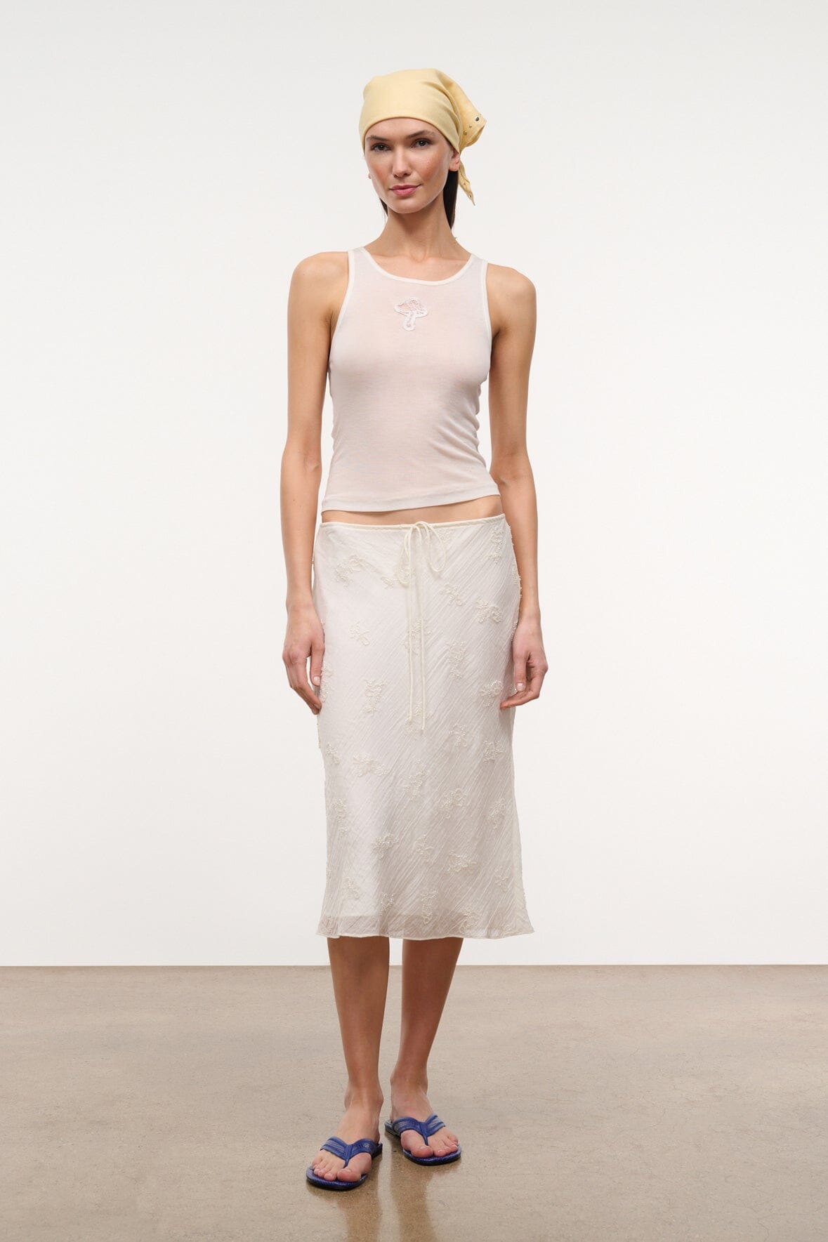Ivory ribbed tank top with delicate front embroidery, worn with skirt