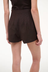 Dark brown tailored shorts with side seams, pleated front, and clean hem