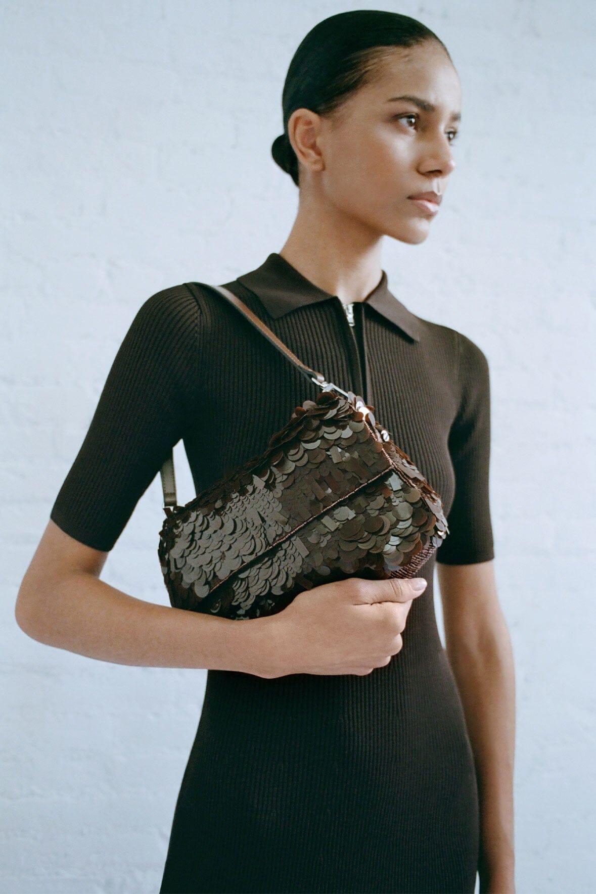 Cacao sequin shoulder bag worn by a model with adjustable shoulder strap