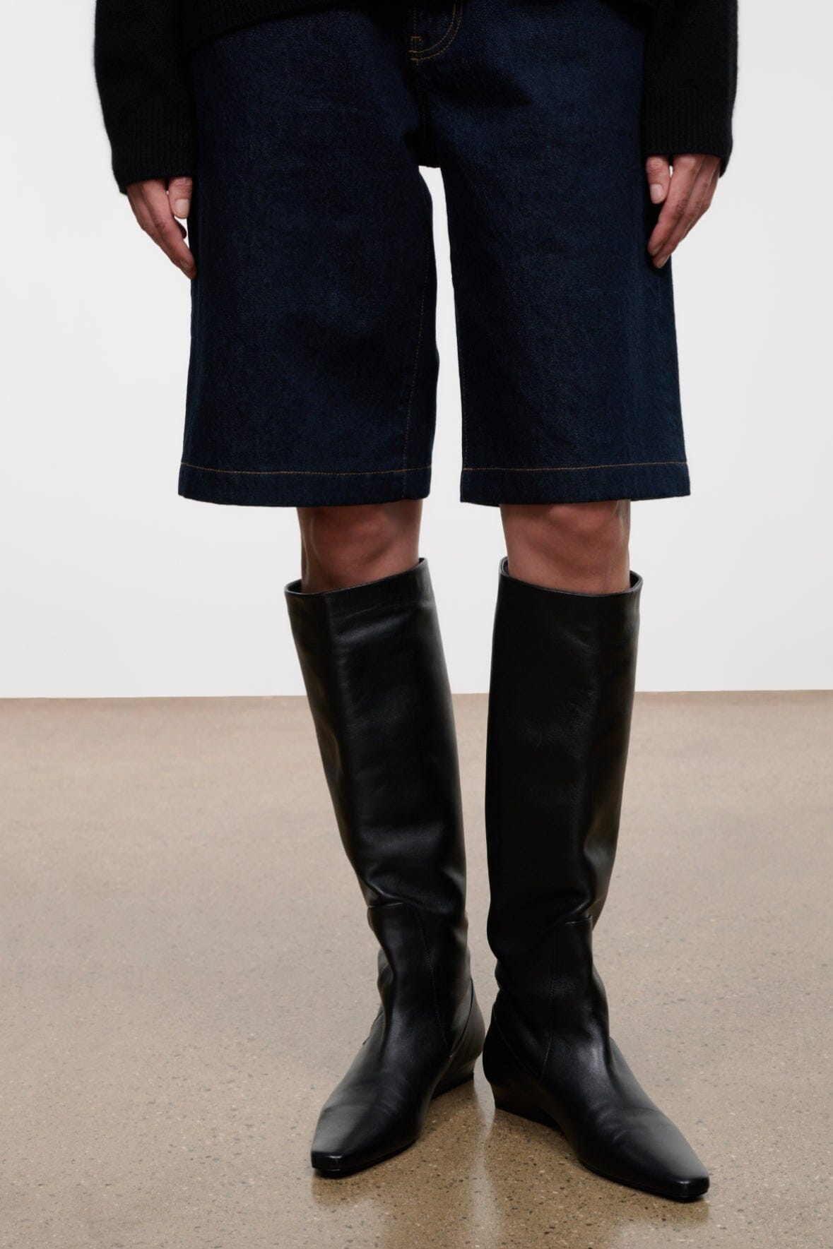 Black knee-high flat pull-on boots, pointed toe and low stacked heel