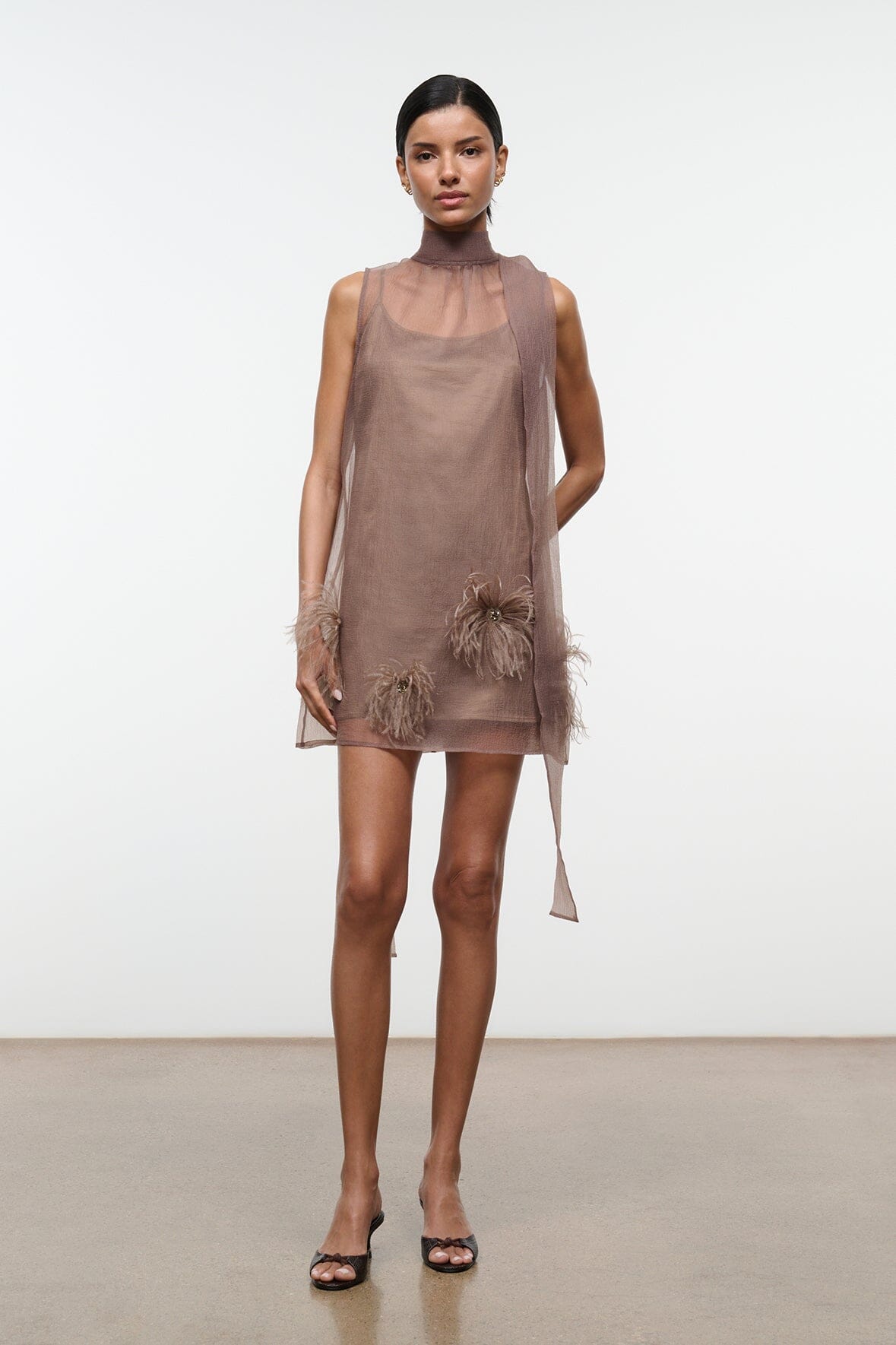 Taupe sleeveless mini dress with high neck and feather-trim accents