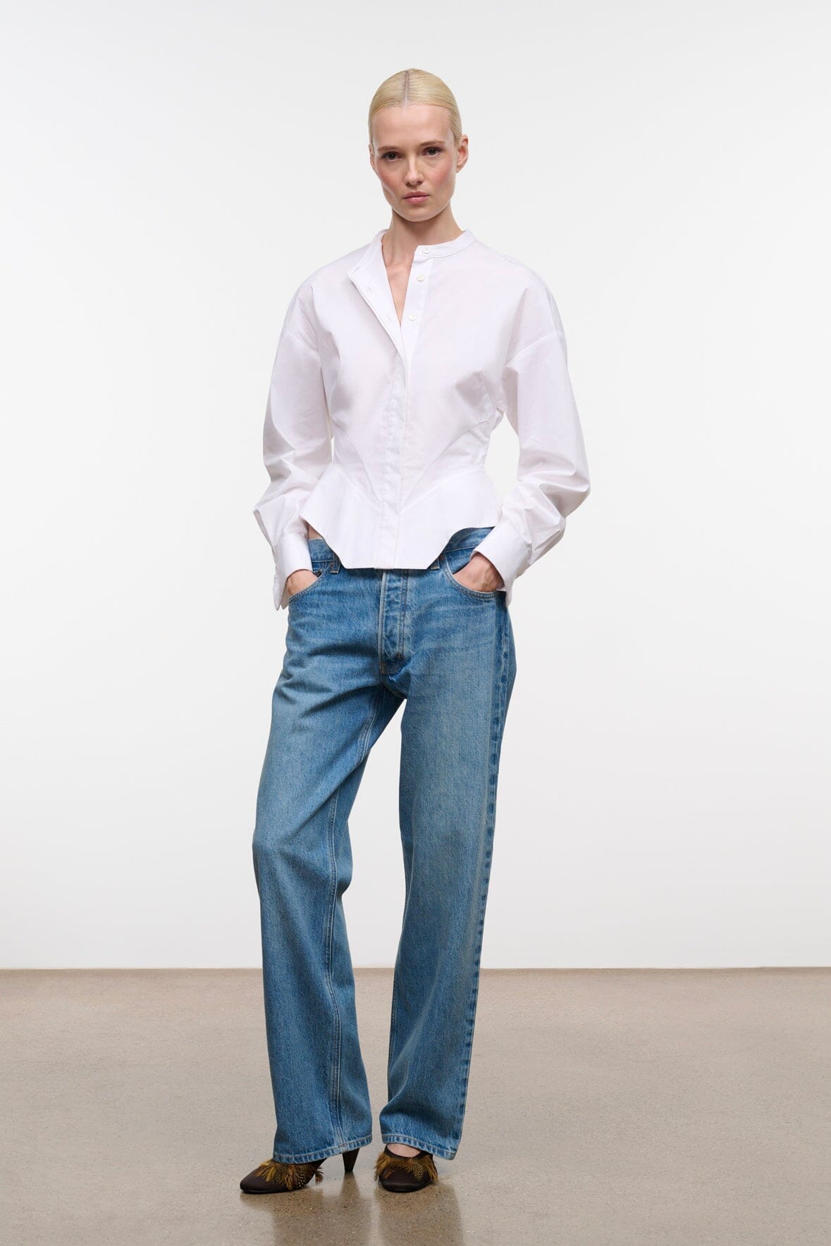 White collared button-up top with long sleeves and hip-length hem