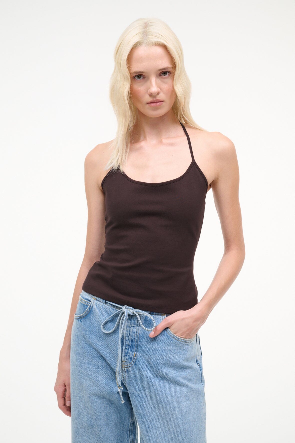 Front view of dark brown halter tank top with thin straps, worn with light blue jeans