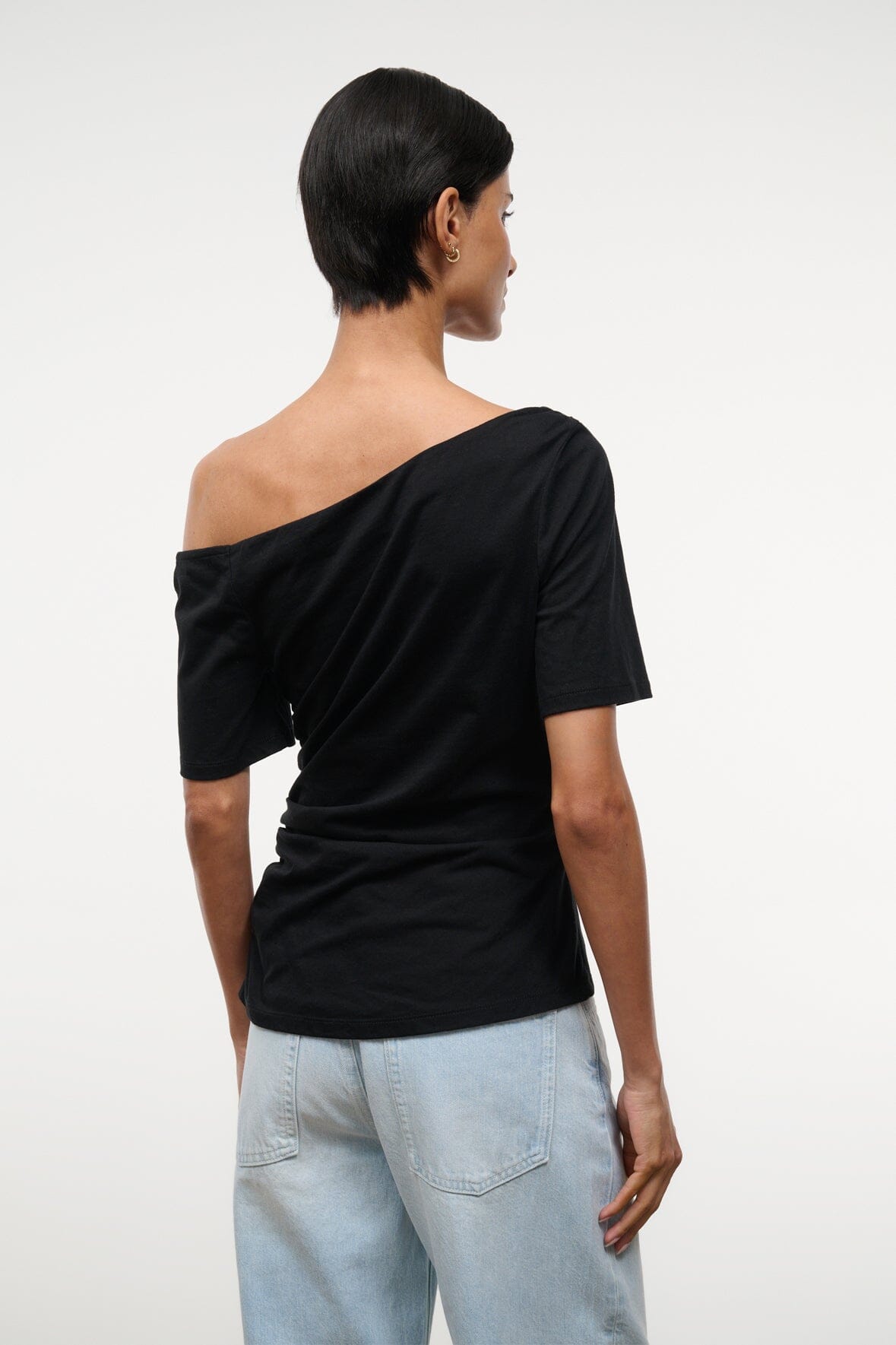 Black Carine top with draped diagonal off-shoulder neckline and short sleeves, back view