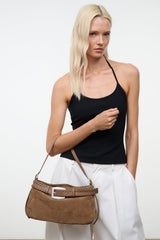 Tan suede shoulder bag with woven strap band and silver buckle on model