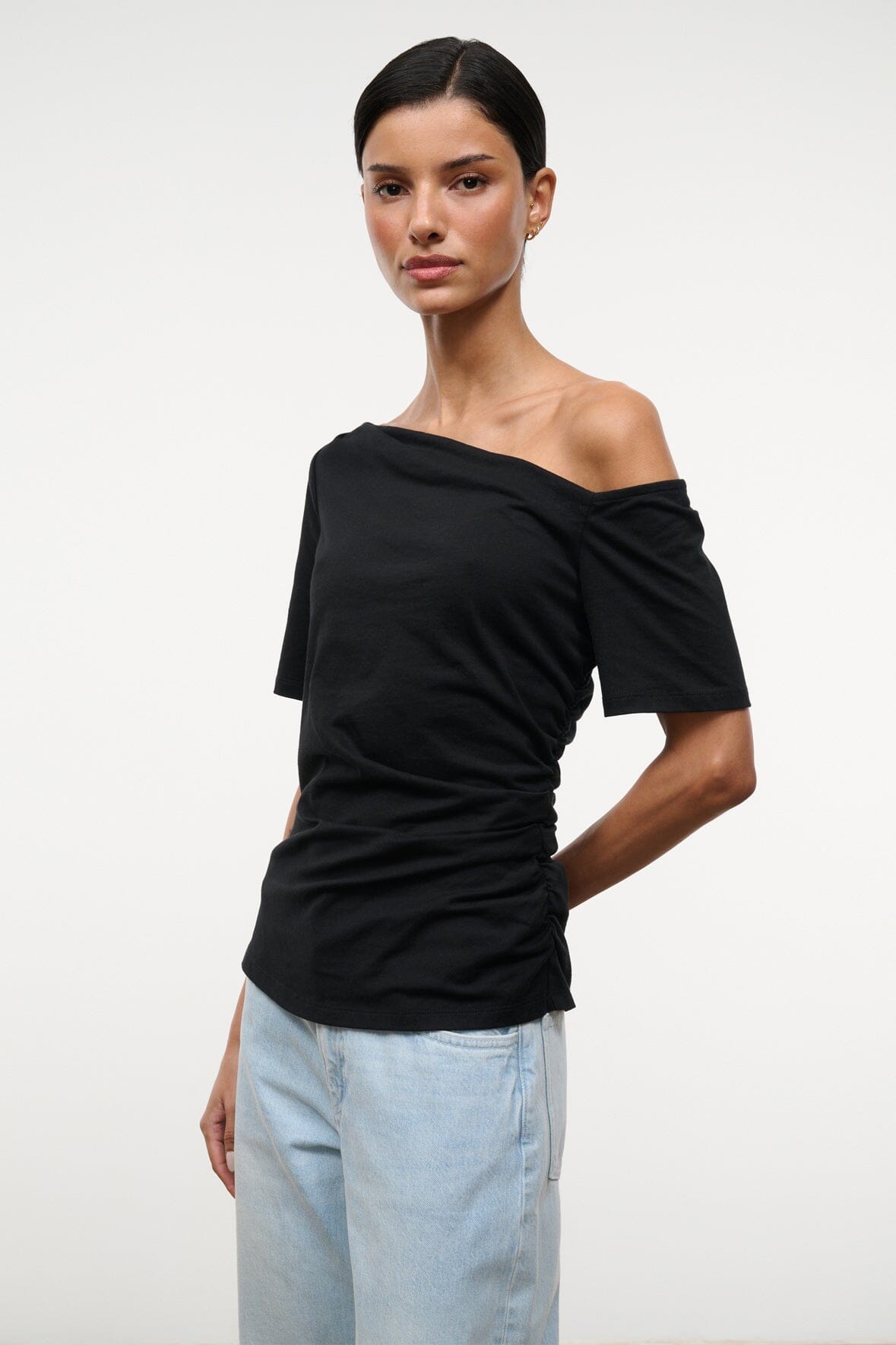 Black Carine top with one-shoulder drape across neckline and short sleeves, front view