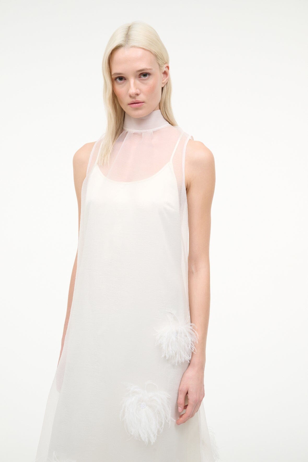 White sleeveless halter dress with feather appliques at hem and right side