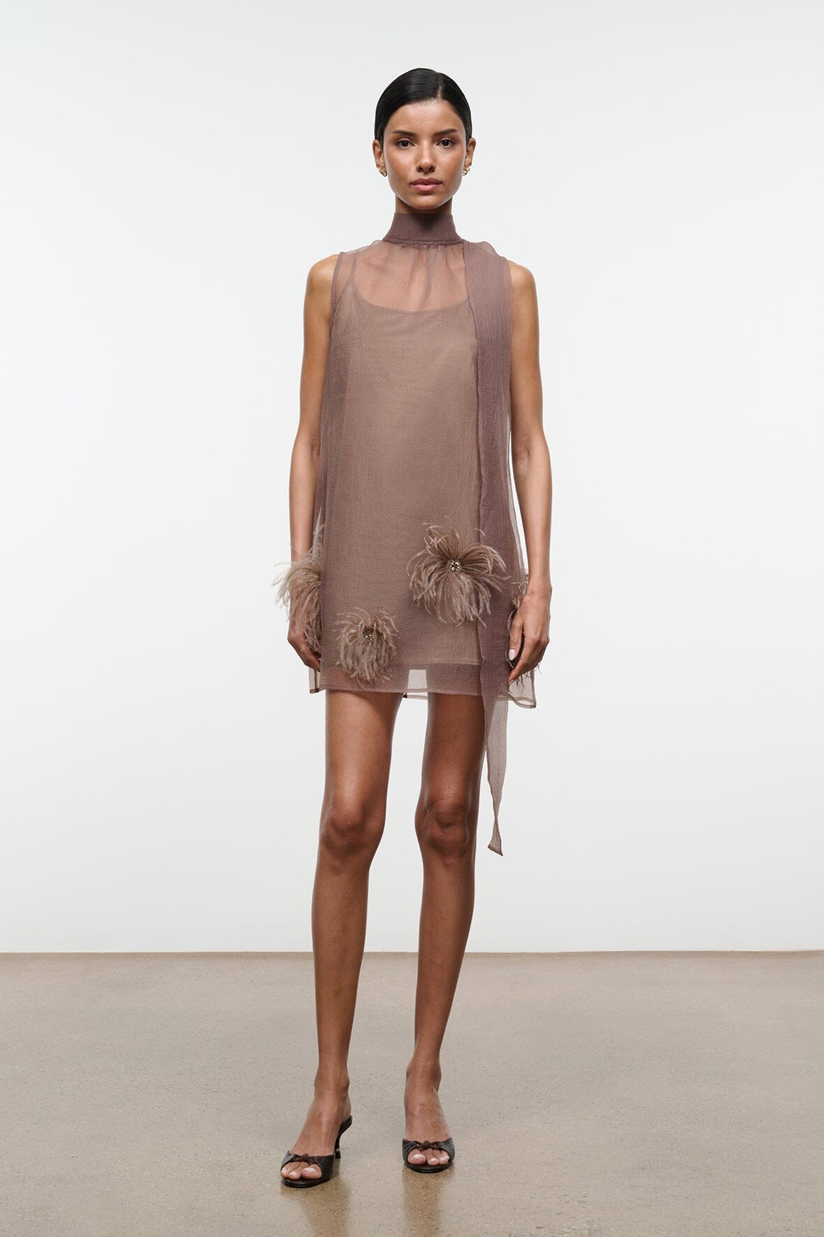 Taupe mini dress with high neckline and feathered trim at hem and cuffs