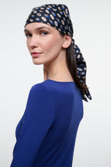 Silk scarf headwrap in dark navy with multicolor circle pattern, tied at side