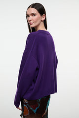 Relaxed cashmere crewneck sweater in deep purple, long sleeves, side view.