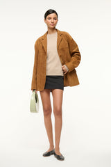 Stone relaxed cashmere crewneck sweater layered with a brown jacket; relaxed fit