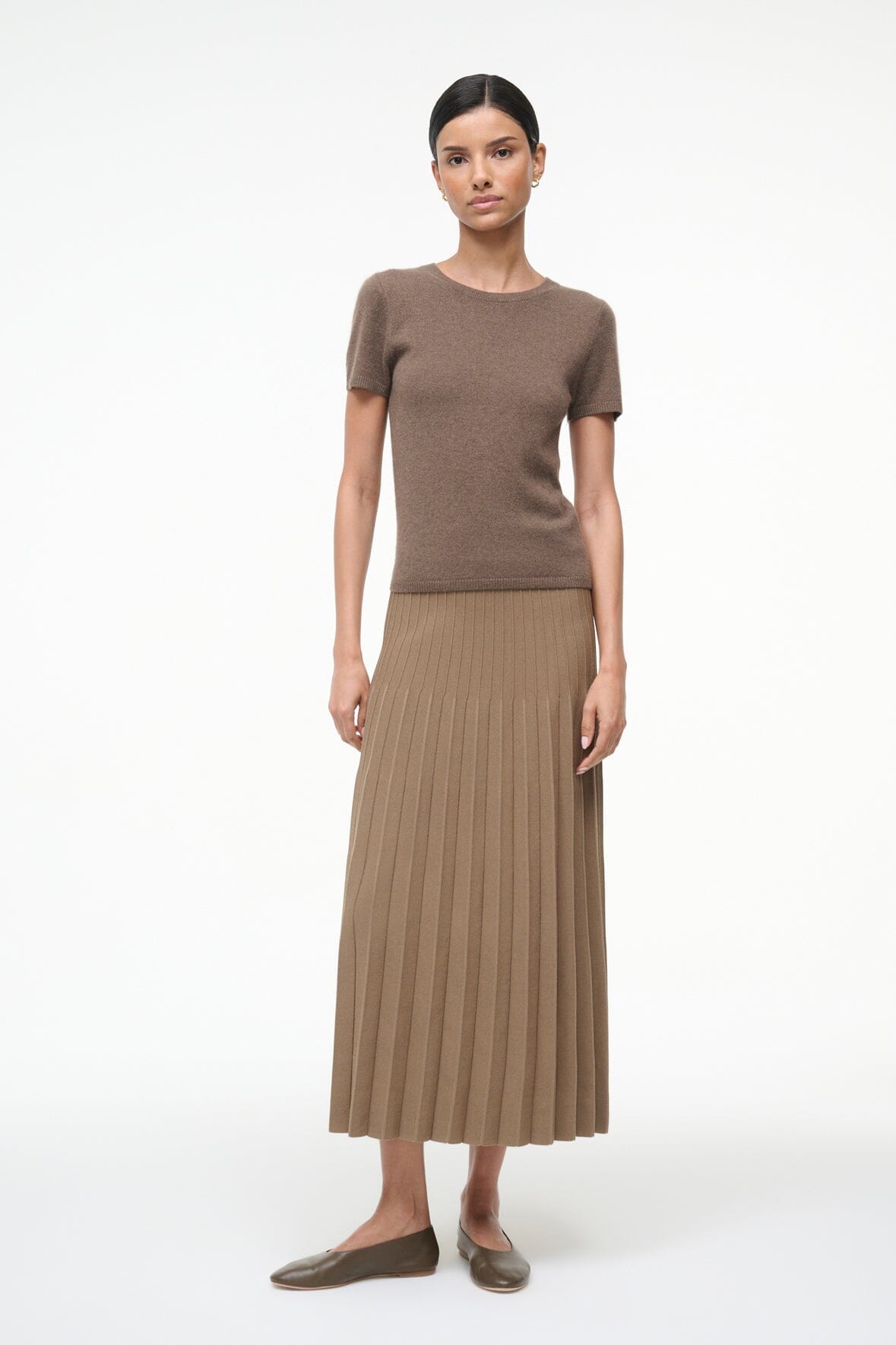 Model in brown ribbed knit short-sleeve top and pleated midi skirt