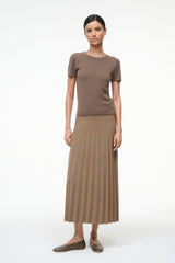 Model in brown ribbed knit short-sleeve top and pleated midi skirt