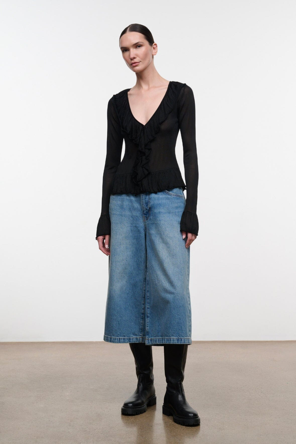 Black long-sleeve V-neck top with ruffled front and peplum hem