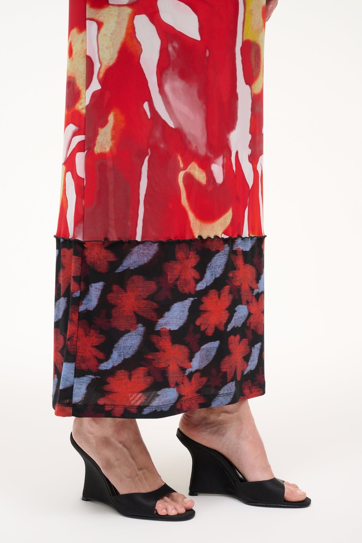 Black high-wedge slide sandals with open toe, worn with a red floral maxi skirt
