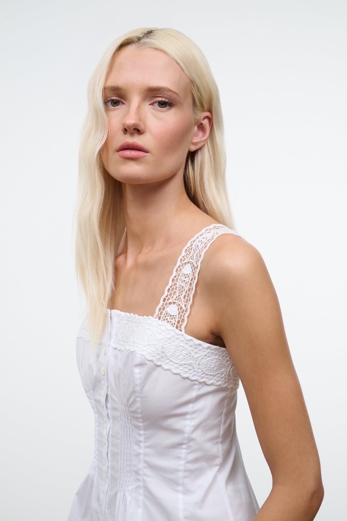 White sleeveless corset-style top with lace-trim shoulder straps