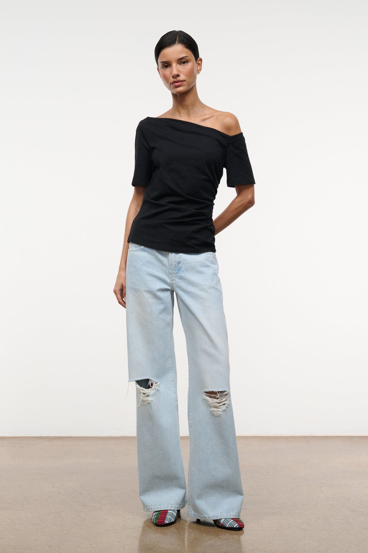 Black Carine top with asymmetrical off-shoulder neckline and short sleeves, full front