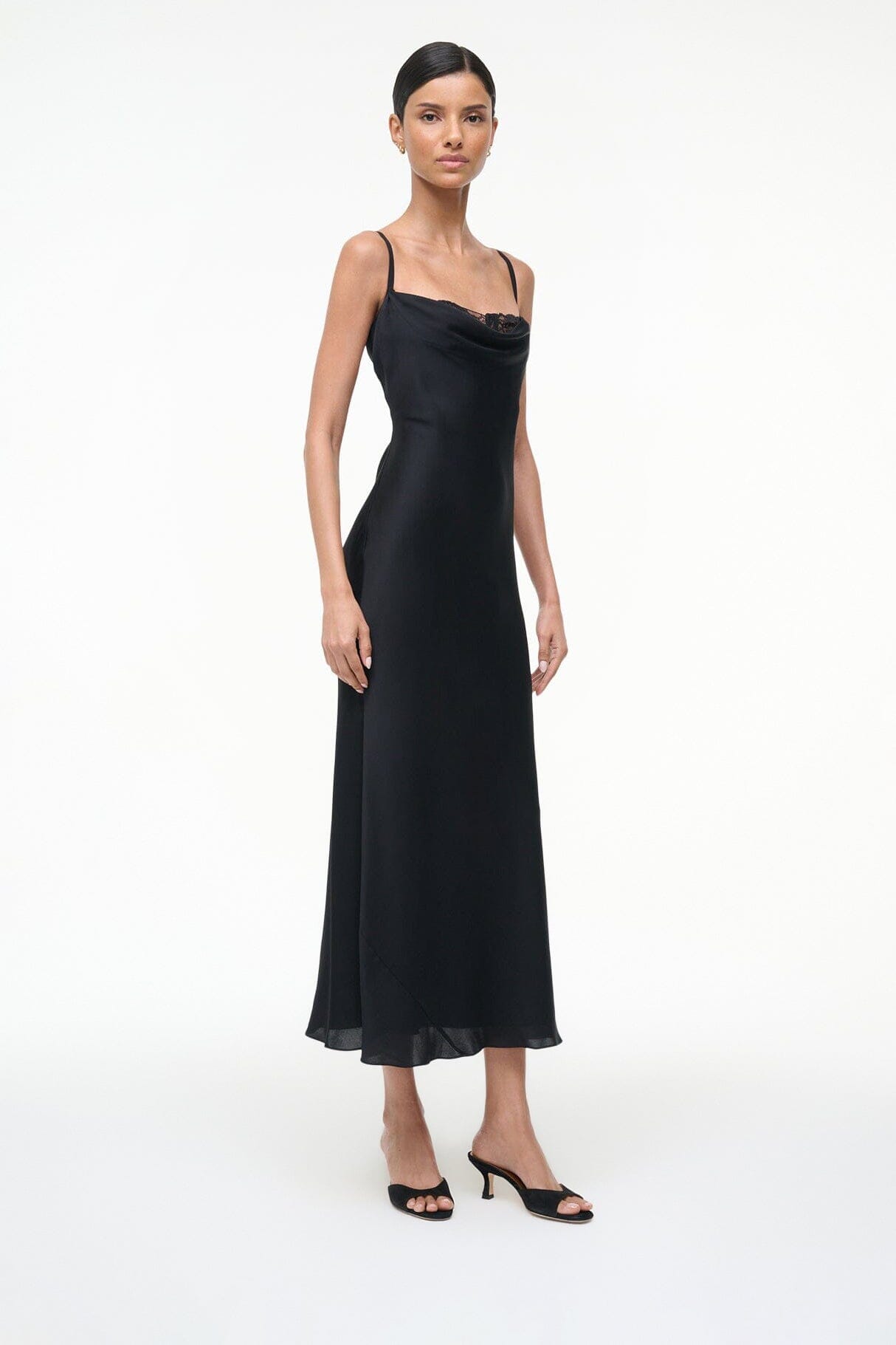 Black suede mule worn with black slip dress, front view of feet