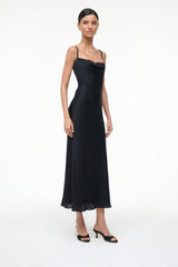 Black suede mule worn with black slip dress, front view of feet