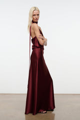 Wine satin halter maxi dress with diagonal halter strap and flowing skirt.