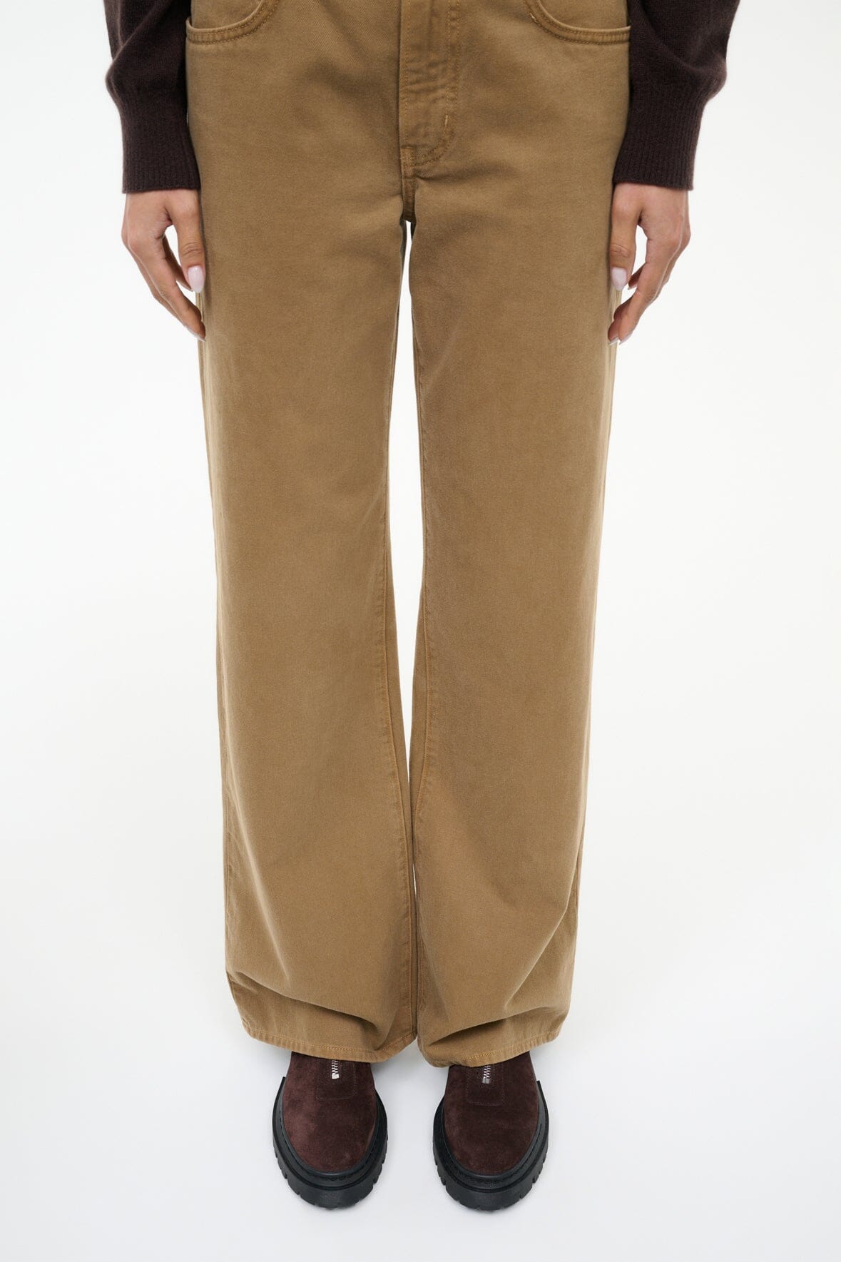 Beige pants worn with espresso suede zip ankle boots and black lug soles