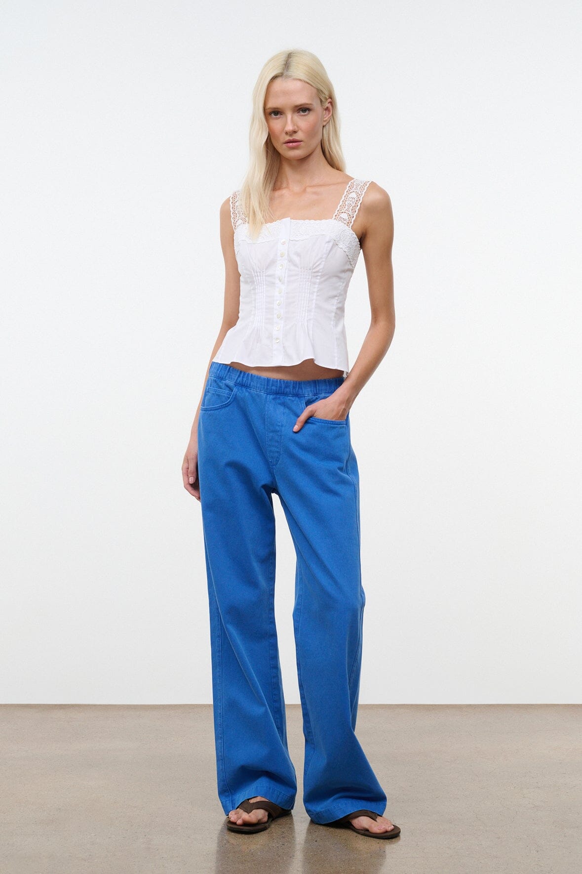 White sleeveless corset-style top with lace trim and structured seams