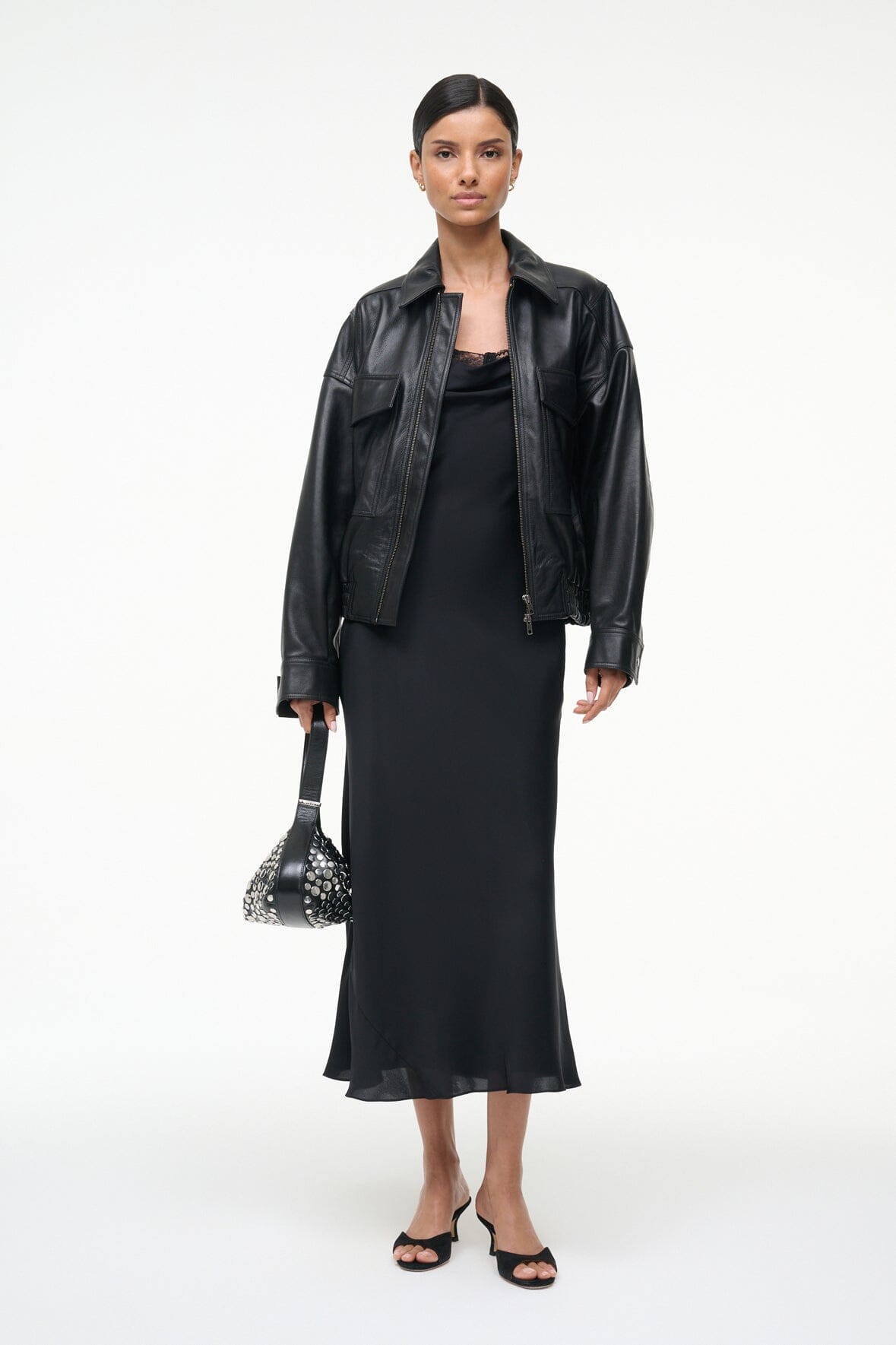 Black silk midi dress with lace-trim neckline, worn with cropped faux-leather jacket