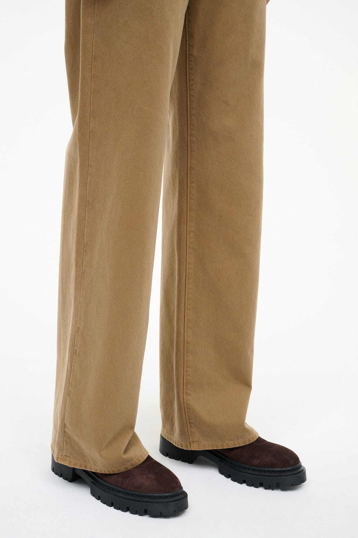 Beige wide-leg pants with espresso suede ankle boots and black lug soles