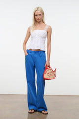 White sleeveless corset-style top with lace-trim straps and pintuck details