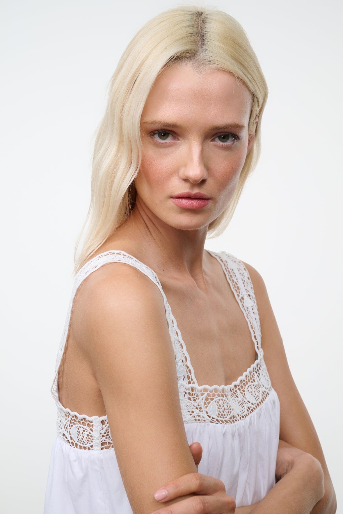 White sleeveless dress with lace-trim square neckline and scalloped trim