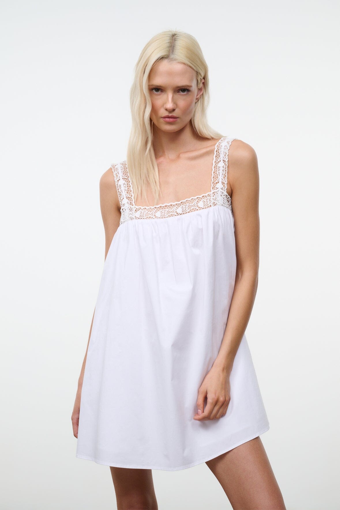 White babydoll dress with lace-trim straps and gathered skirt