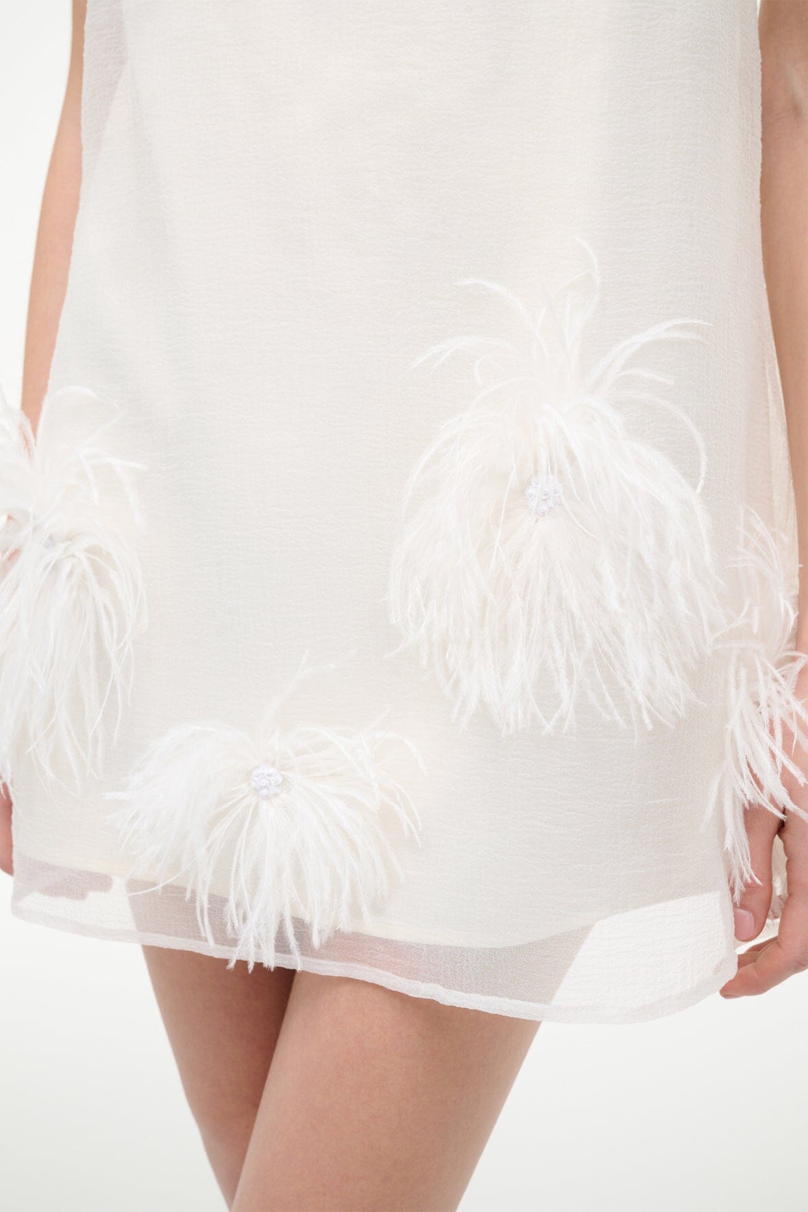 White mini dress with sheer layer and white feather embellishment skirt