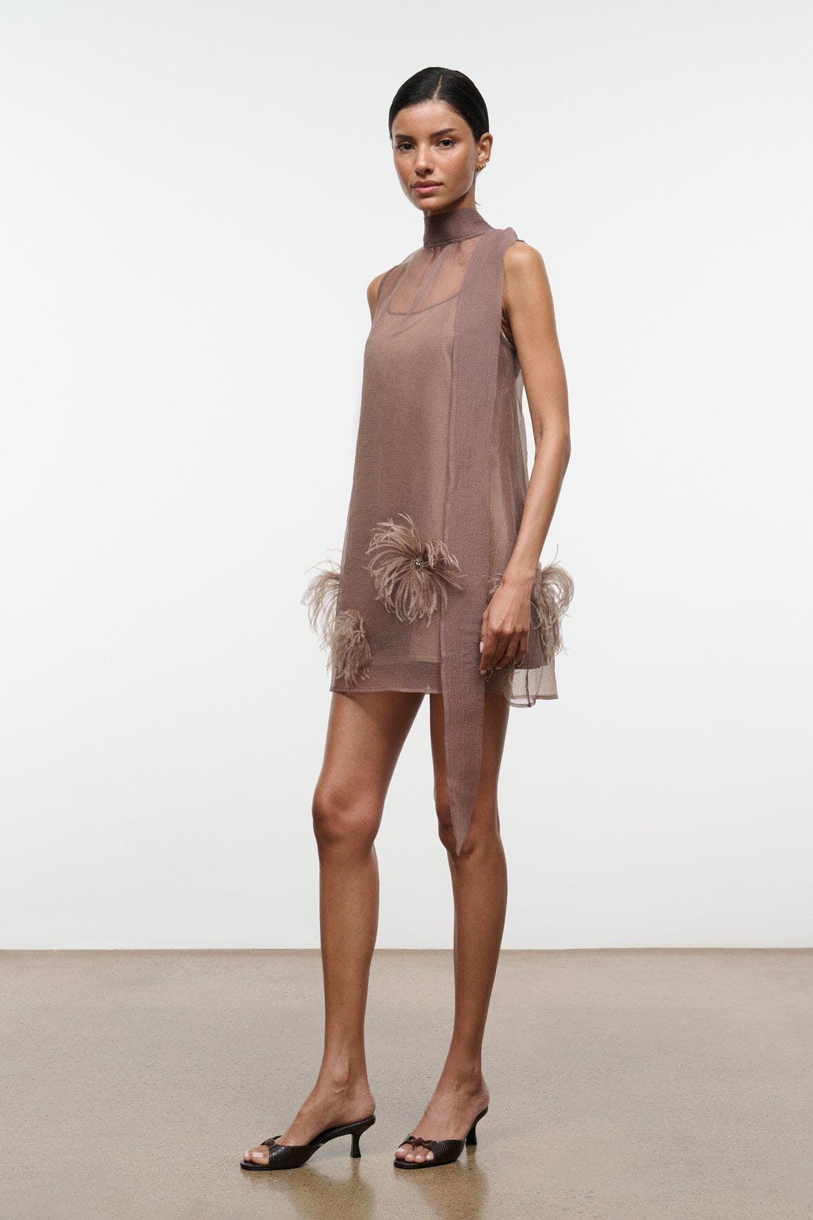 Taupe mini dress, high neck sleeveless silhouette with feathered accents near hem