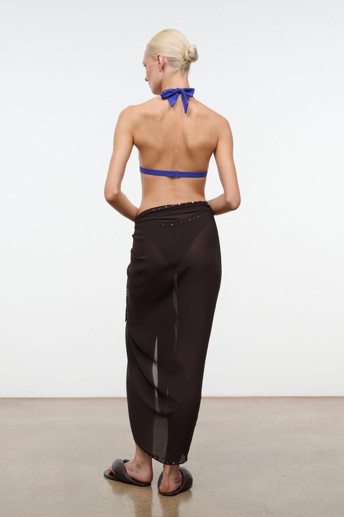 Back-view brown sarong wrap skirt with draped fold and slim tied waistband