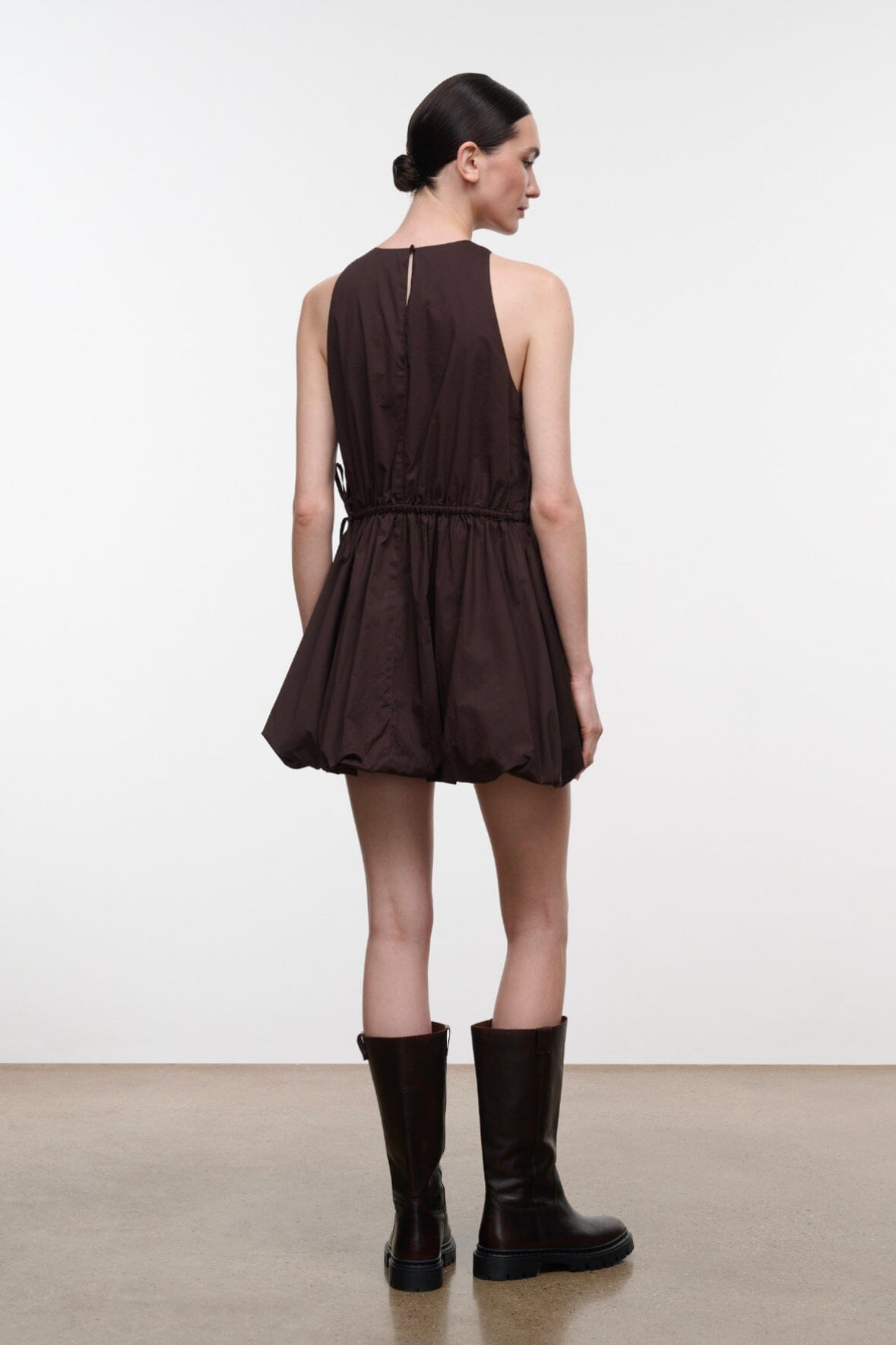 Dark brown sleeveless mini dress, back view, gathered waist with ruched skirt